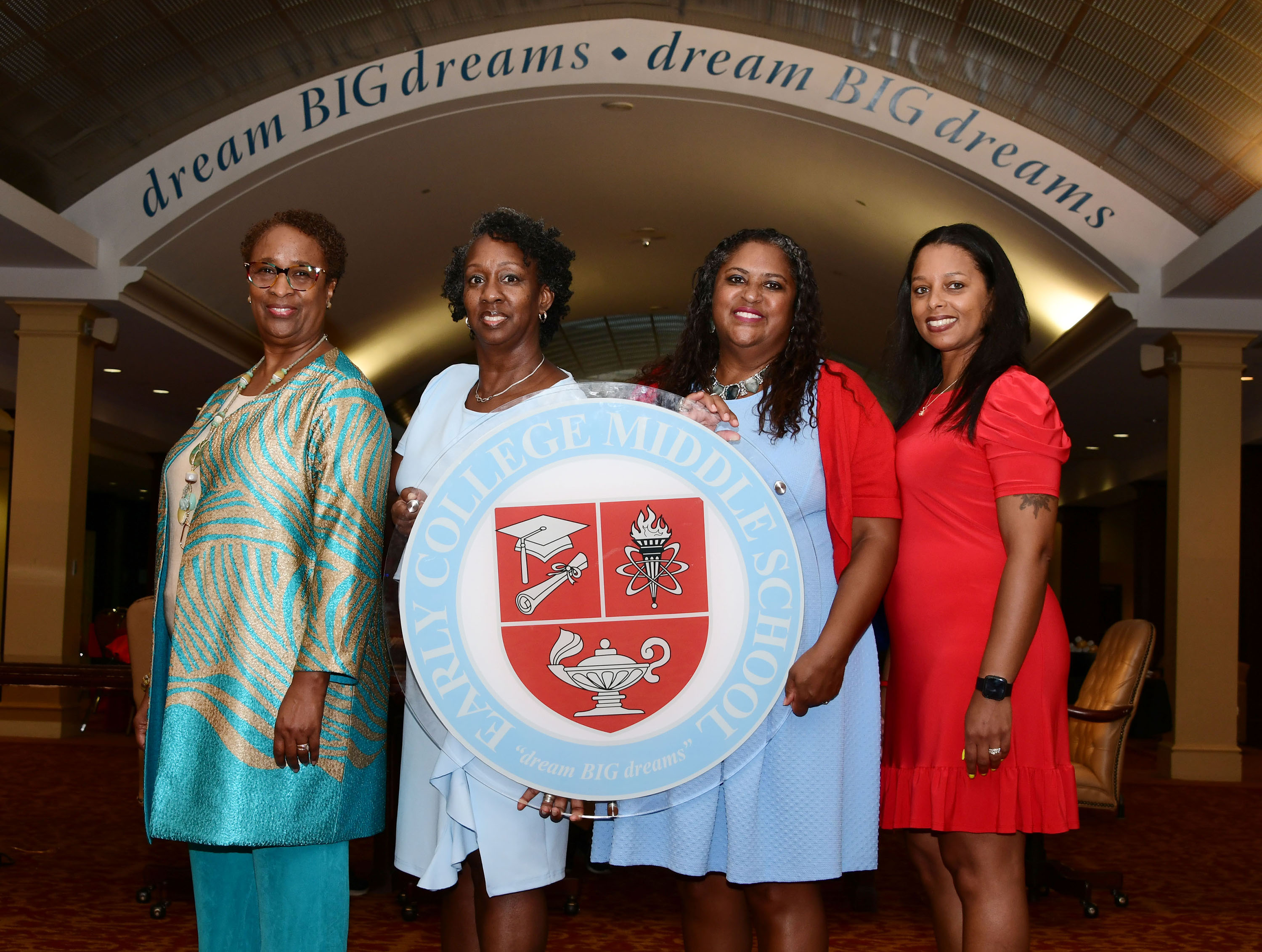 Dr. Marsha Horton, Dr. Dara Savage, Dr. Evelyn Edney and Dr. Nyia McCant show the Early College Middle School emblem.