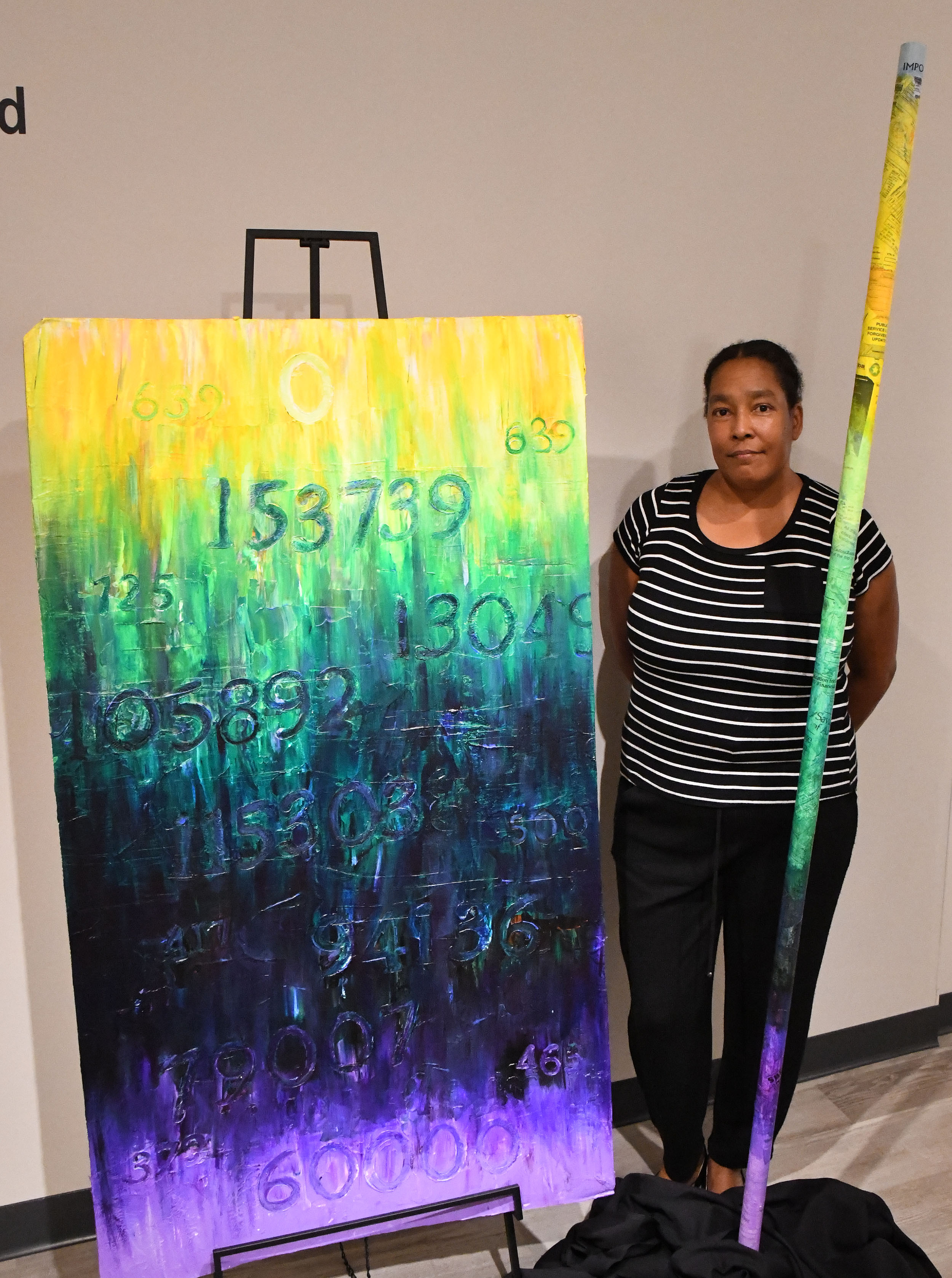 Lori Crawford, Associate Professor of art, stands next to her works which capture her student loan challenges. 
