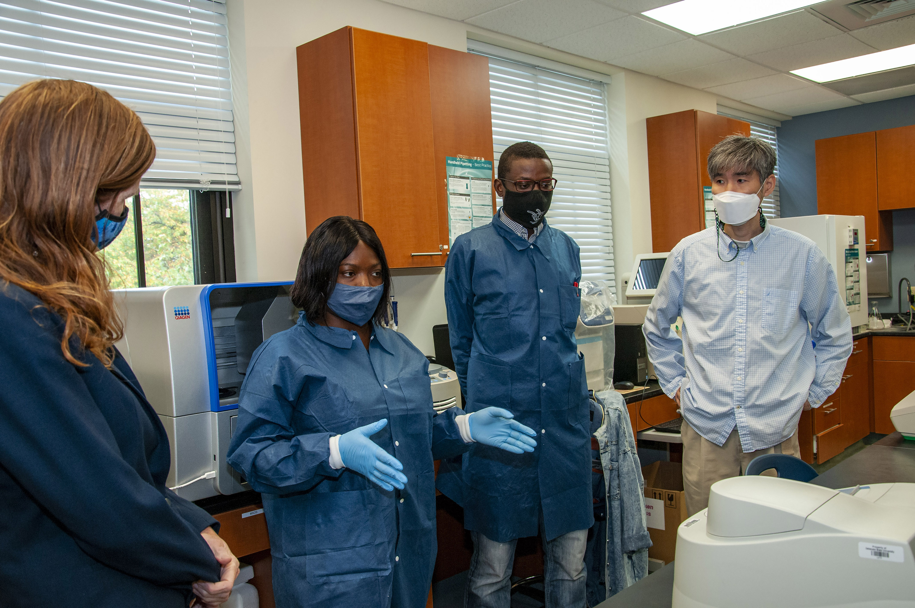 Samantha Power (far left) listens to students explain their work in the Microbiology Lab.