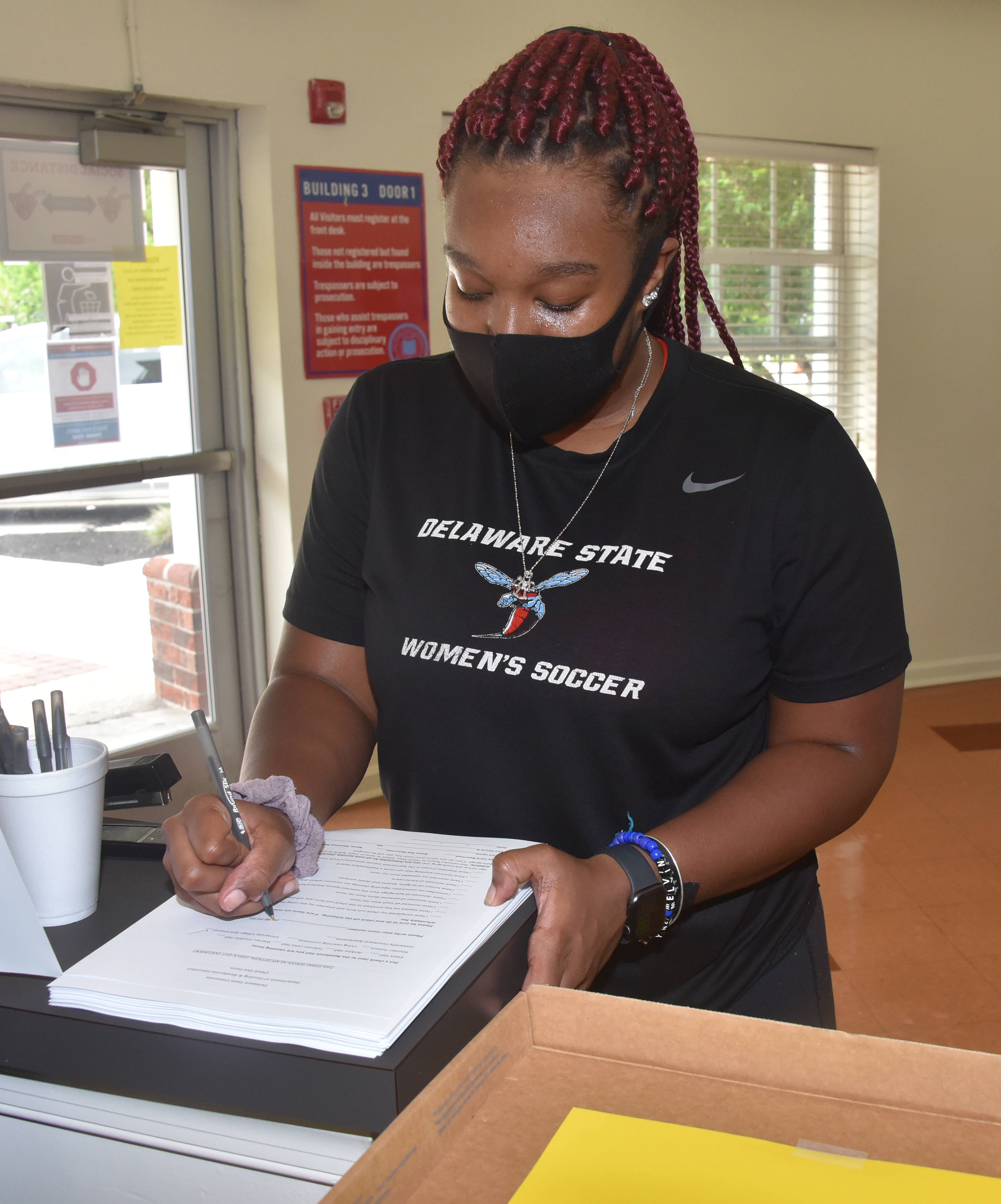 Jasmine Warren, a recent graduate, completes a check-out form, which she will leave with her University Village apartment key.