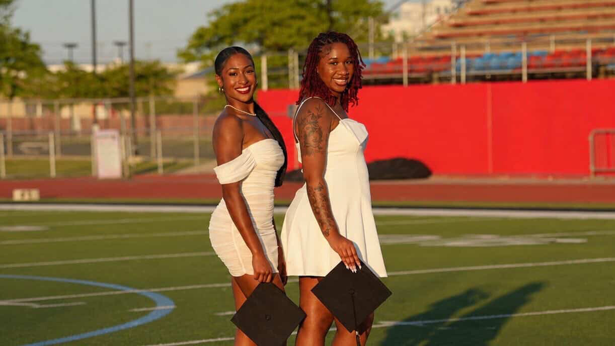 Tia and Sanaiyah all smiles as they get ready to turn their tassels and cross the stage.