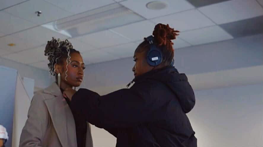 Sanaiyah attaches a microphone to Tia as they prepare content for the 2026 Battle of Legends.