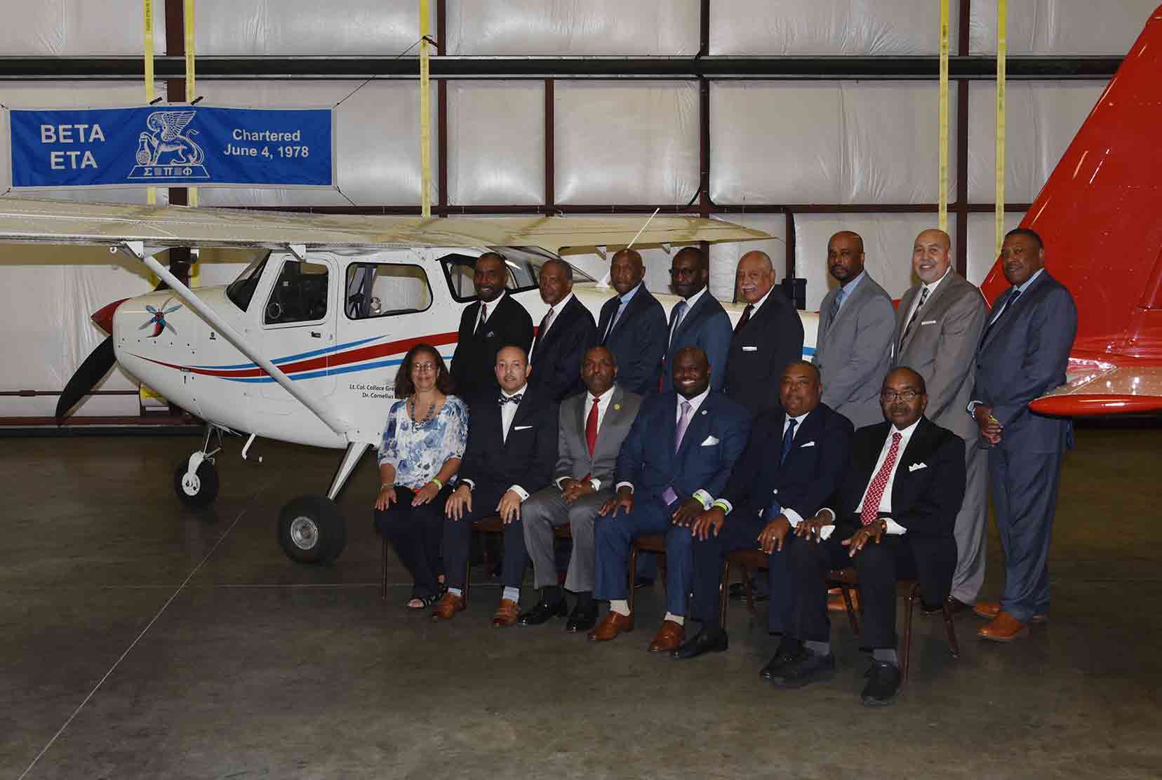 Beta Eta members pose at the Del State plane renamed after two of its members. (L-r, bottom row, Dr. Cornelius Gaither's daughter Carol Clark, Alfred Spencer, Collace Greene Jr., University President Tony Allen, William Allen, Wesley Wilson; (top) Tony Edwards, Dr. Karl Brockenbrough, Dr. Harvey White, Juan Roach, Theodore Greer, Dr. Michael Casson, Vincent Ross, and John Ridgeway.