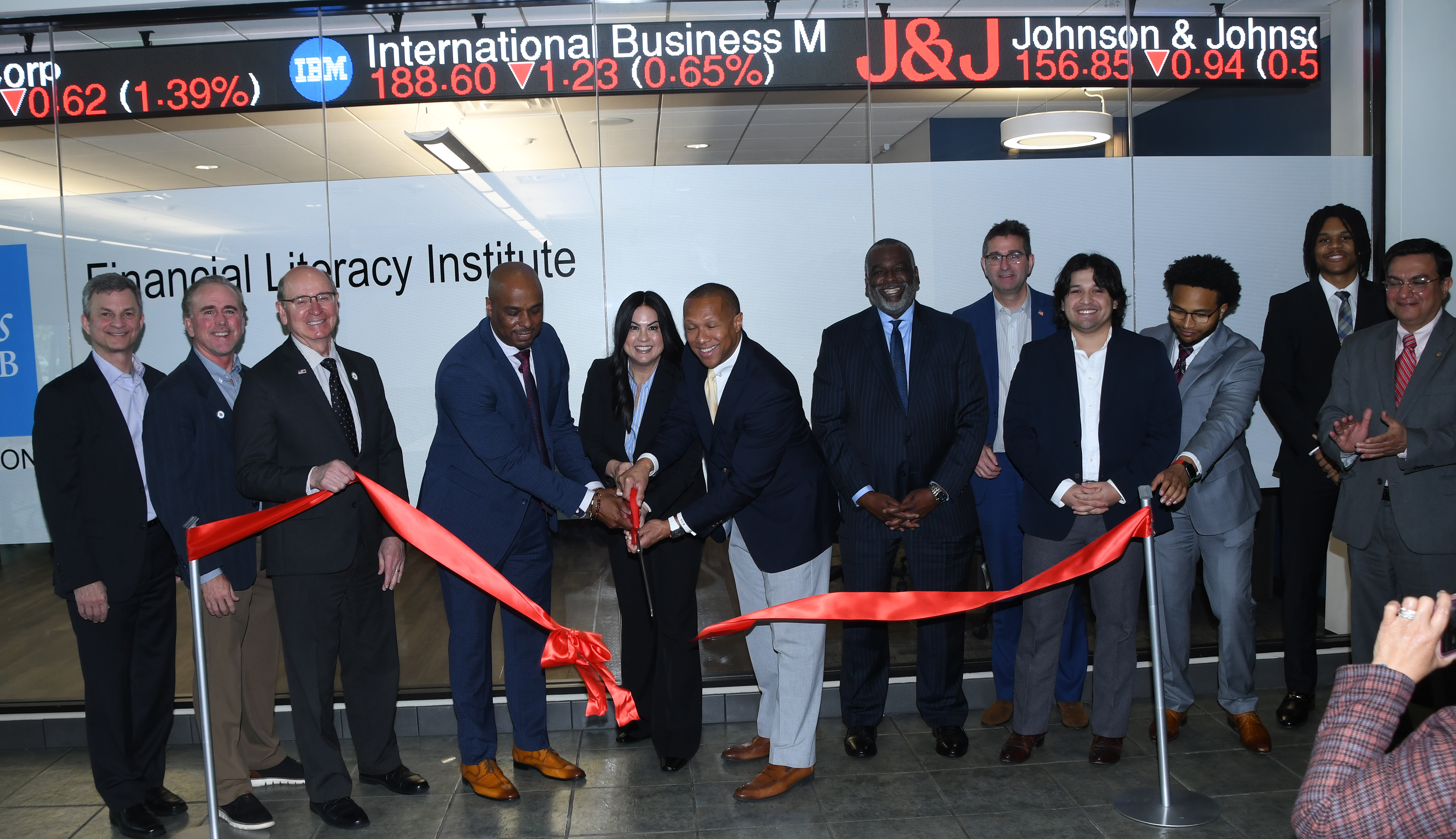 Dr. Michael Casson, Sherri Trombley and Greg Coverdale cut the ribbon for the Charles Schwab Financial Literacy Institute.