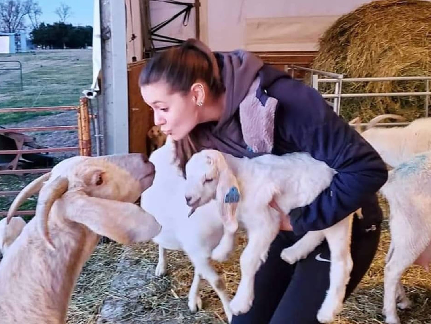 Ms. Lynch in her undergraduate days with farm animals; she speaks highly of the University's Agriculture Program.