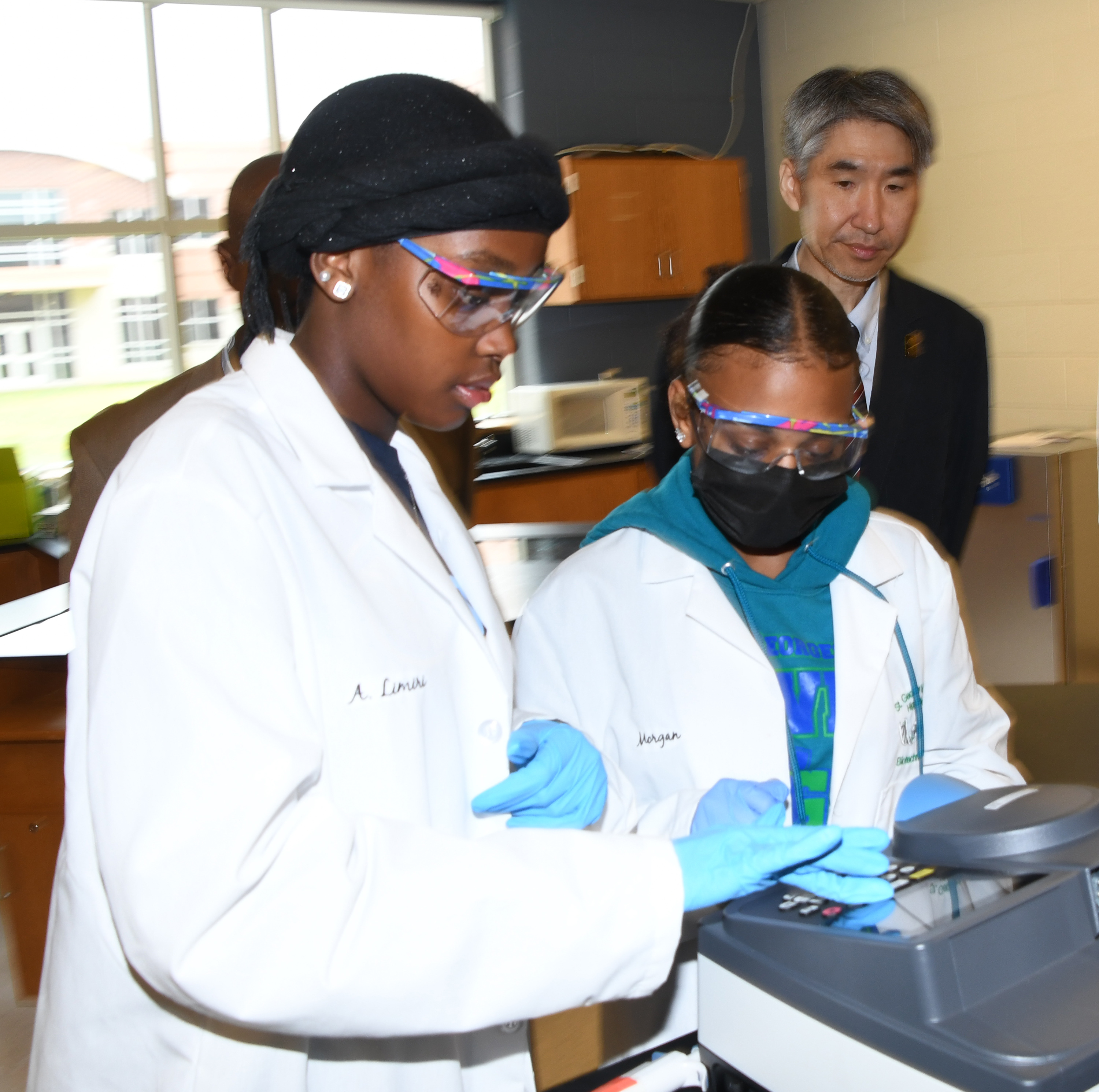 St. George student demonstrate their laboratory technical while Dr. Jung-Lim Lee observes.