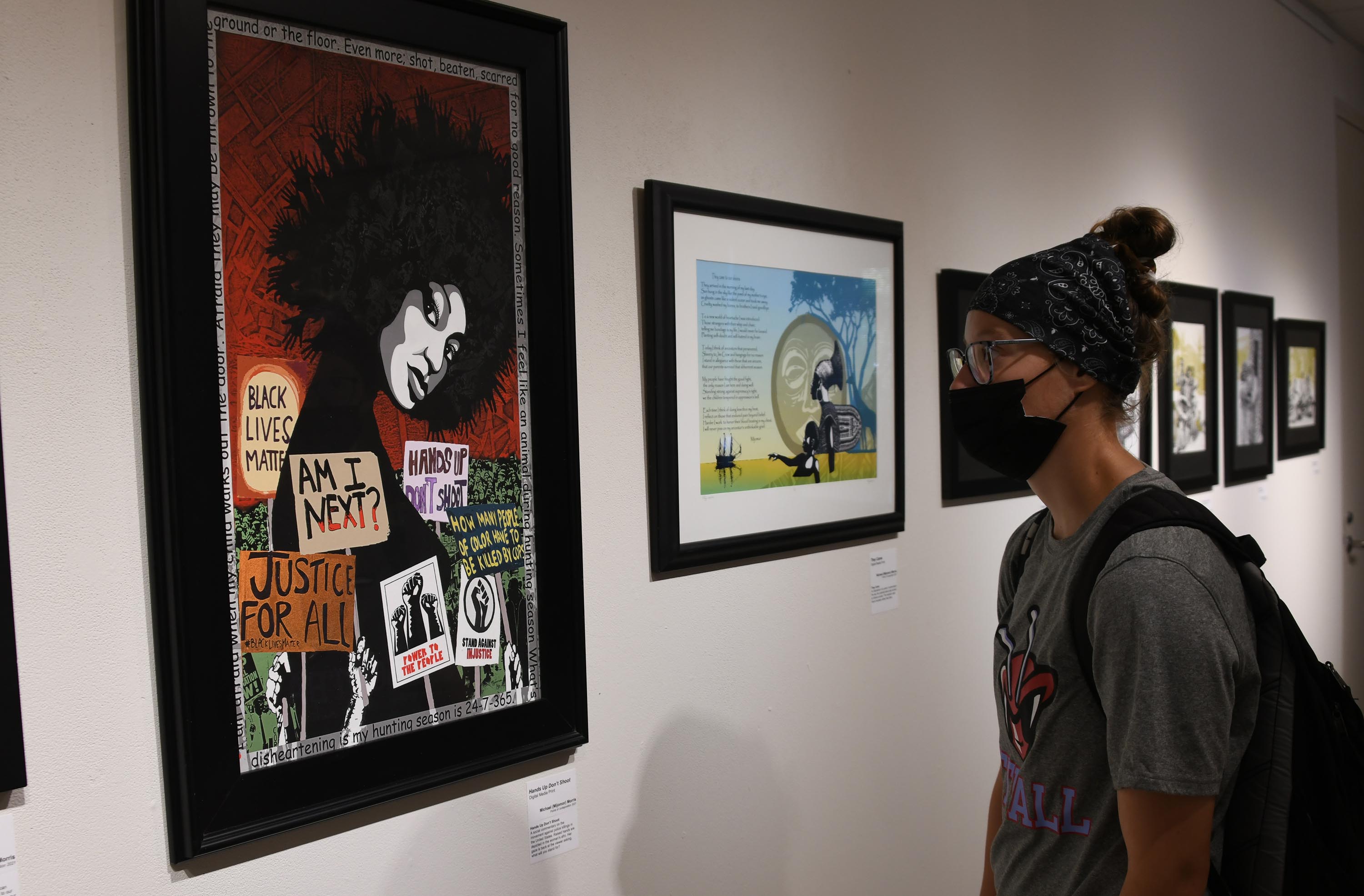 Michael Morris' work "Hands Up, Don't Shoot" draws the attention of a Del State student.