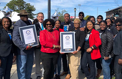 A group of participants celebrate the University's new status as a Guiness World Record holder (twice over).