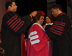 Her sons Roy Sudler Jr. and Travis Mishoe Sudler remove Dr Luna Mishoe's robe that she was wearing.