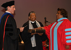 Gov. John Carney administers the oath of office to Dr. Mishoe, while her sister Rev. Rita Paige holds the bible.