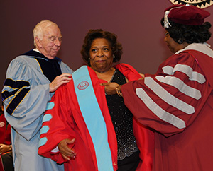 Dr. Donald Ross (l), founder of Wilmington Univ., and Dr. Thelma Thompson, former UMES president place her new robe on.