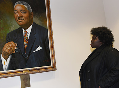 Carter at the portrait of the late Sen. Herman Holloway, sponsor of the 1993 bill giving the institution University status.