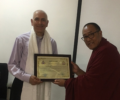 Dr. Matthew Bobrowski is recognized for his volunteer teaching by a representative of the Emory Tibet Science Initiative.