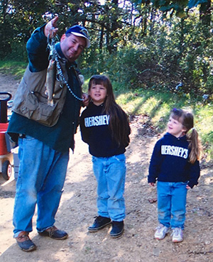 Caitlin Berchtold (center) as a young one with her dad, Brian Berchtold, and her sister Kasey