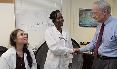 Sen. Carper gets to know (i-r) student researchers Fernanda Lima and Ashley Anderson.
