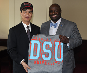 Dezhou University Chairman Liu Wenlie (l) show hat and blanket gifts presented by Provost Tony Allen (r),