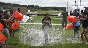Dominica Thomas runs through the traditional water gauntlet that each young pilot ran through upon completing their solo flight.