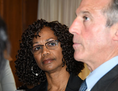 Dr. Sheridan Kingsberry listens to Gov. John Carney on the day he enacted a social worker law she helped advocate. 