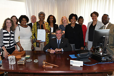 Gov. John Carney poses a large group of DSU social work faculty and graduates who got the state to pass and enact HB 311.
