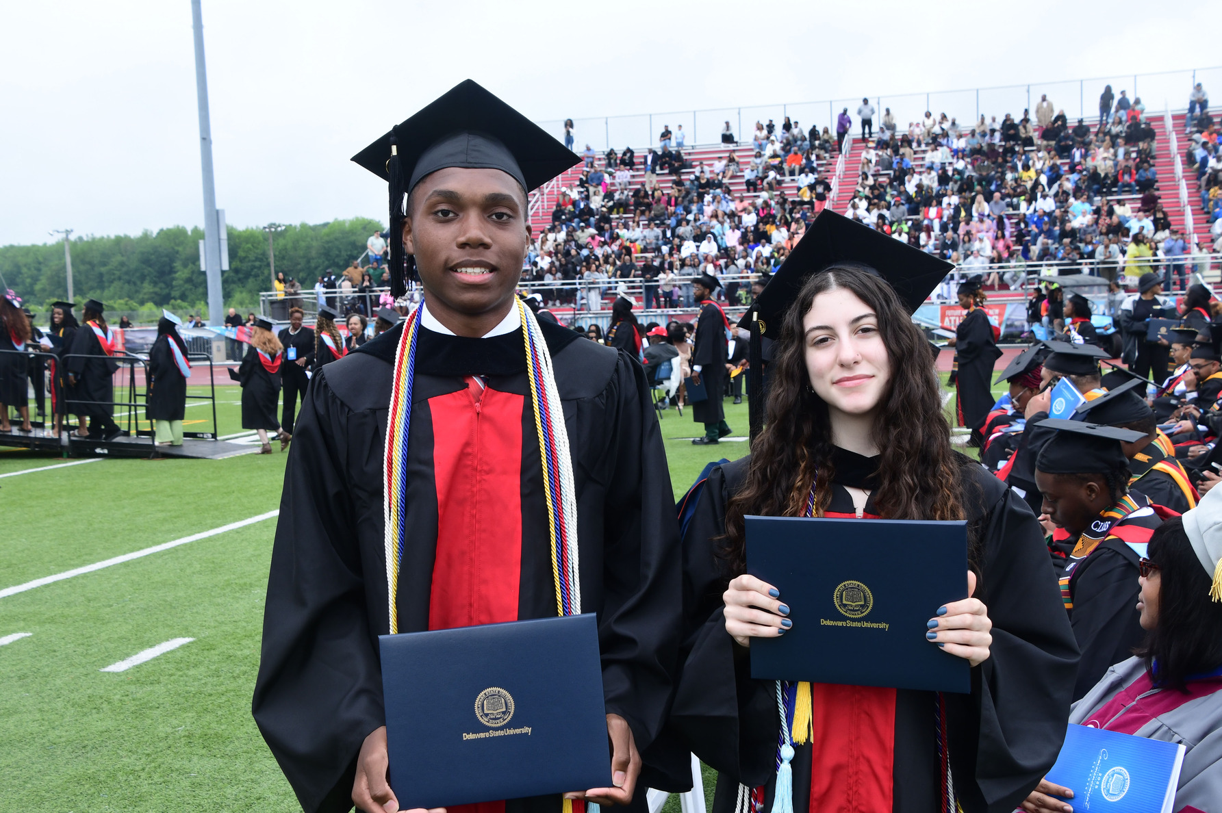 (L–R) DSU Early College School graduates Christopher Richardson and Kara McCarthy hold their associate degrees.
