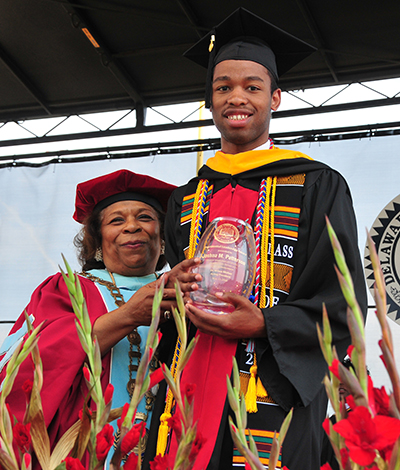 Interim DSU President Wilma Mishoe present Joshua Patterson with the Presidential Leadership Award.