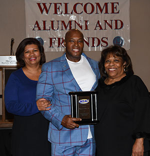 Ronnie Shaw Sr. (center) with his wife Linda (l) and University President Wilma Mishoe.