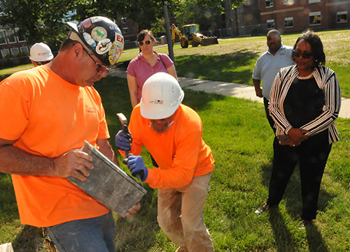 Wohlsen Construction Co. workers pry open the time capsule that was located in the Laws Hall cornerstone almost 60 years ago.