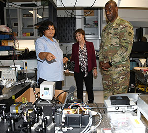 Dr. Renu Tripathi (l) shows Dr. Melissa Harrington and Maj. Gen Cedric Wins the array of optics technology she works with.