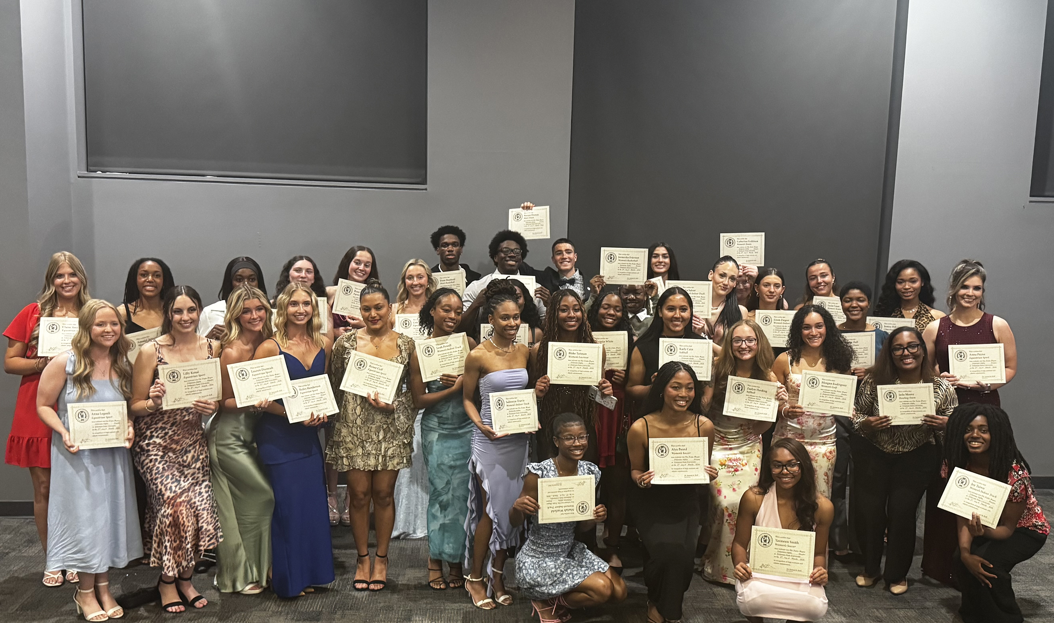 Some of the 79 inductees of the Del. Alpha Chapter of Chi Sigma Alpha National Athletic Honor Society proudly show certificates.