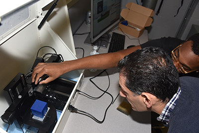 Jameel Brice, sophomore information technology major, shows Dr. Marwan Rasamny the operation of a milling machine.