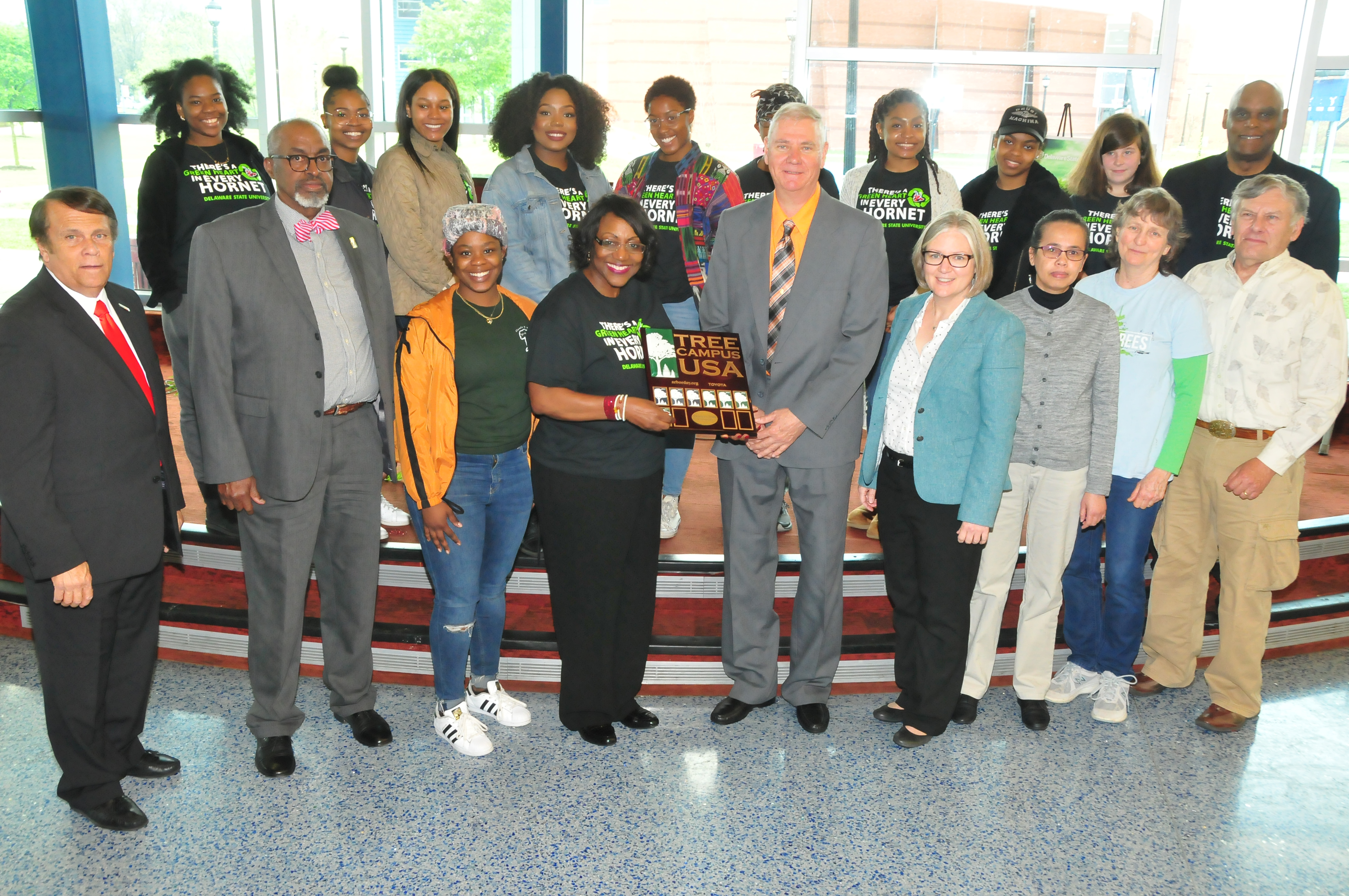 Dr. Vita Pickrum (center) receives the Tree Campus USA renewal designation on behalf of DSU from Dr. Michael Valenti, Delaware state forester. They are flanked by other DSU officials and Roteract and Interact student organizations.