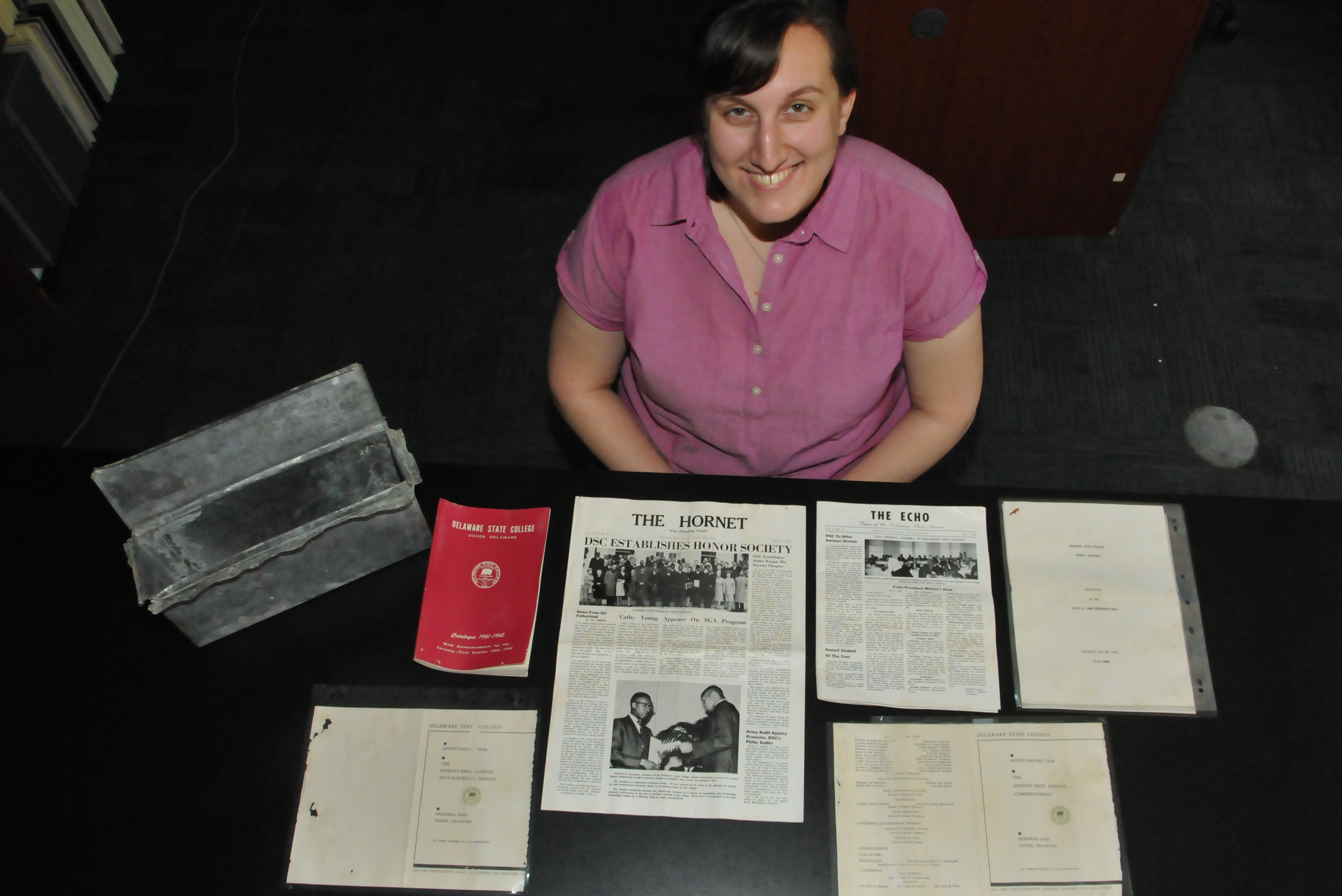 Rejoice Scherry, University archivist, shows the contents of the 1957 Laws Hall time capsule that was recently extracted and opened. The building is being demolished to make way for the construction of a new residential hall.