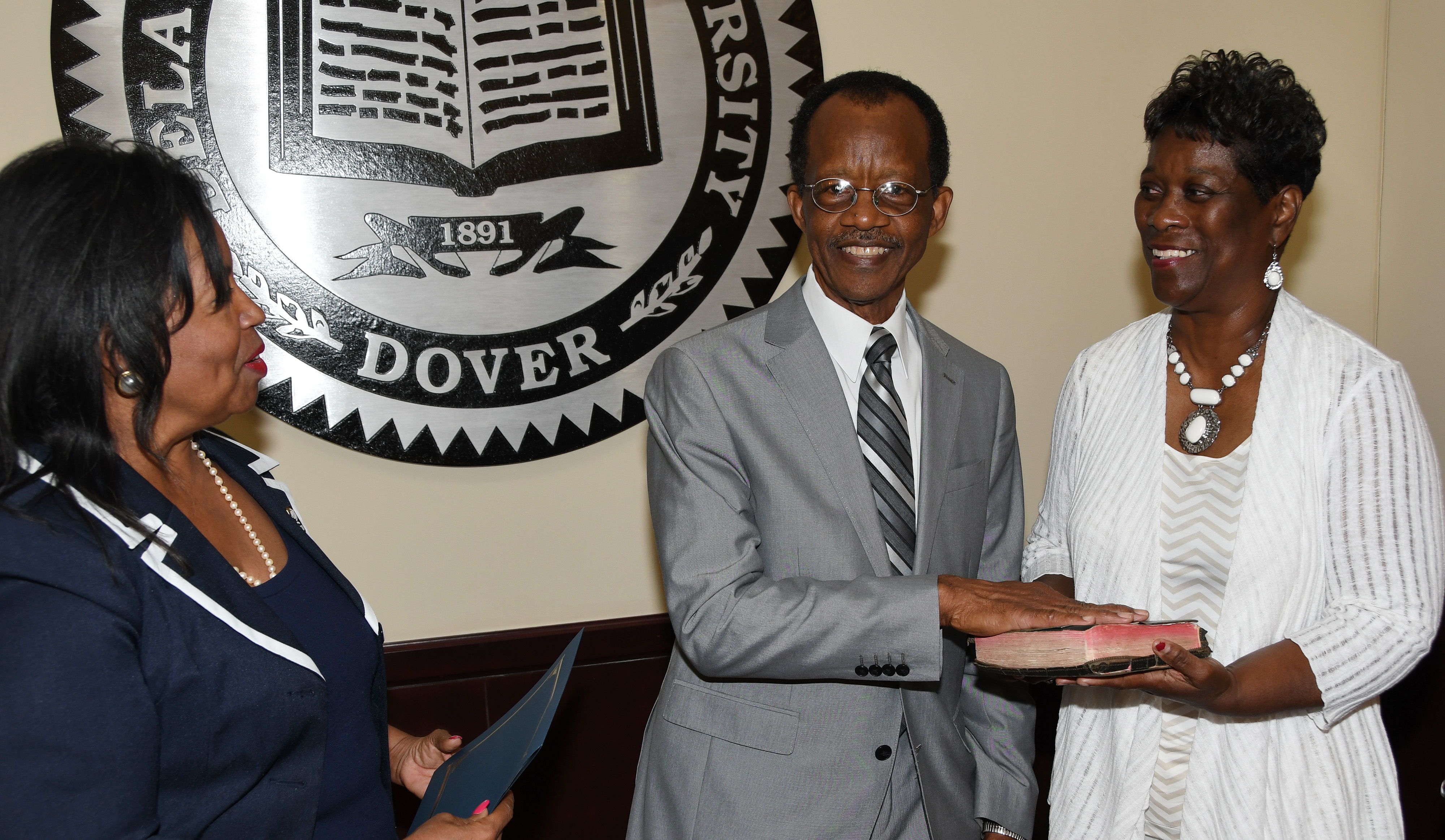 Harold Stafford (center) takes the Board of Trustees oath from Board Interim Chair Devona Williams (l) while his wife Velvia looks on.