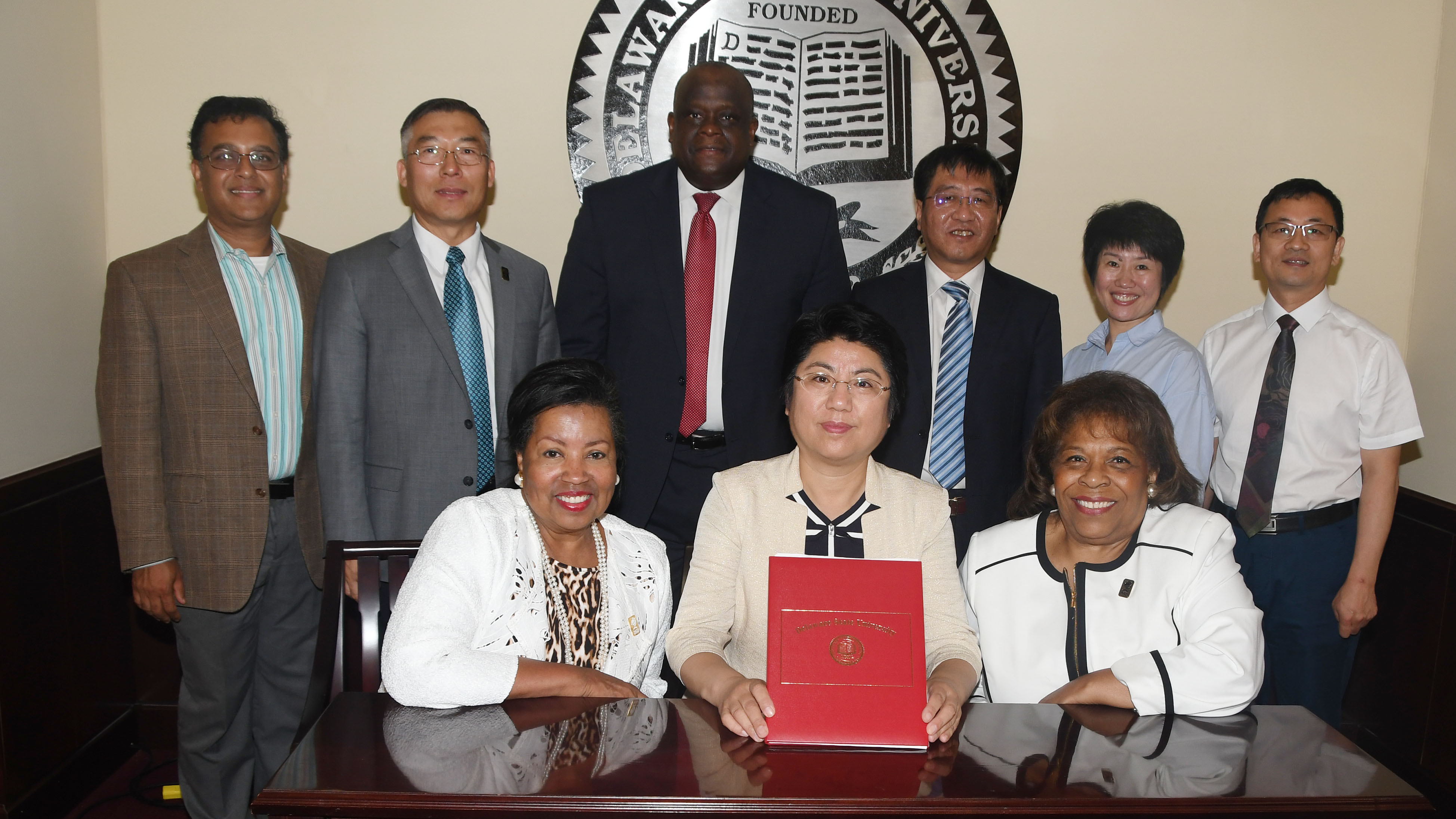 (L-r seated) Dr. Devona Williams, DSU Board of Trustees chair; Changchun University of Science & Technology VP Su Zhongmin and DSU President Mishoe; (standing l-r) Dr. Mukti Rana, Physics chair; Dr. Fengshan Liu, VP of International Affairs; Antonio Boyle, VP of Strategic Enrollment; as well as the CUST delegation, Dr. Jin Guang-Yong, dean of the CUST Science School; Dr. Zhang Yining, dean of the College of Foreign Languages; and Dr. Xu Yanping, director of the College of Foreign Languages.