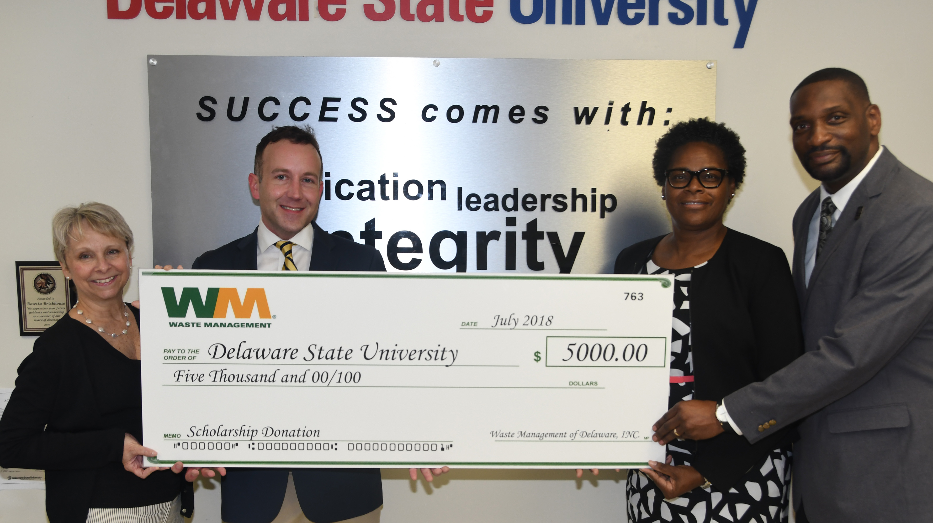 Waste Management donates $5,000 toward DSU scholarships: (l-r) Judy Diogo, president of the Central Del. Chamber of Commerce, Paul Beane of Waste Management, Rosetta Brickhouse, executive director of DSU Facility Operations, and Howard Gibson, associate director of Custodial & Grounds Services.