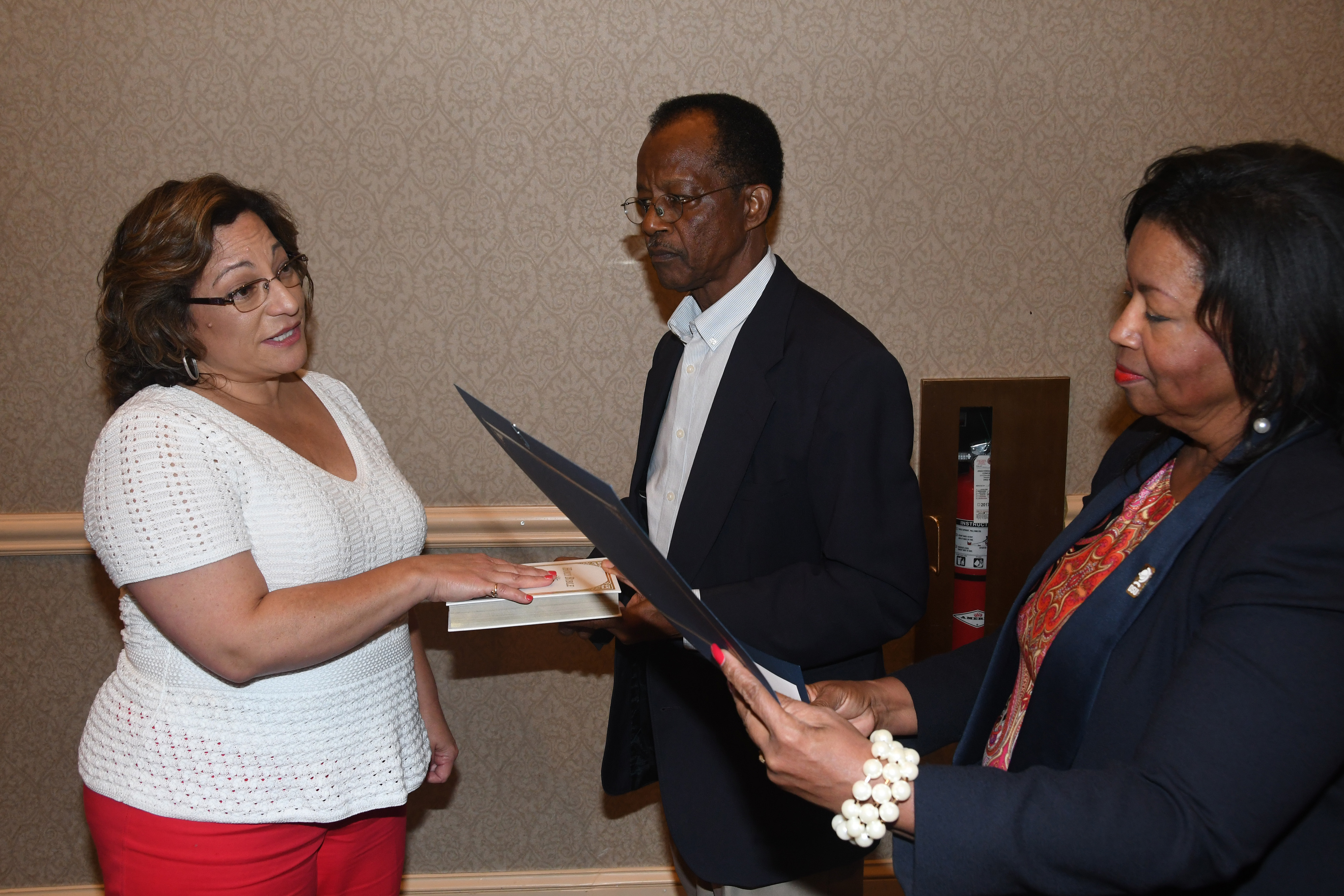 New Board of Trustees member Margie Lopez Waite (l) is sworn in by Board Chair Dr. Devona Williams during the Sept. 20 meeting. Trustee Harold Stafford holds the bible.