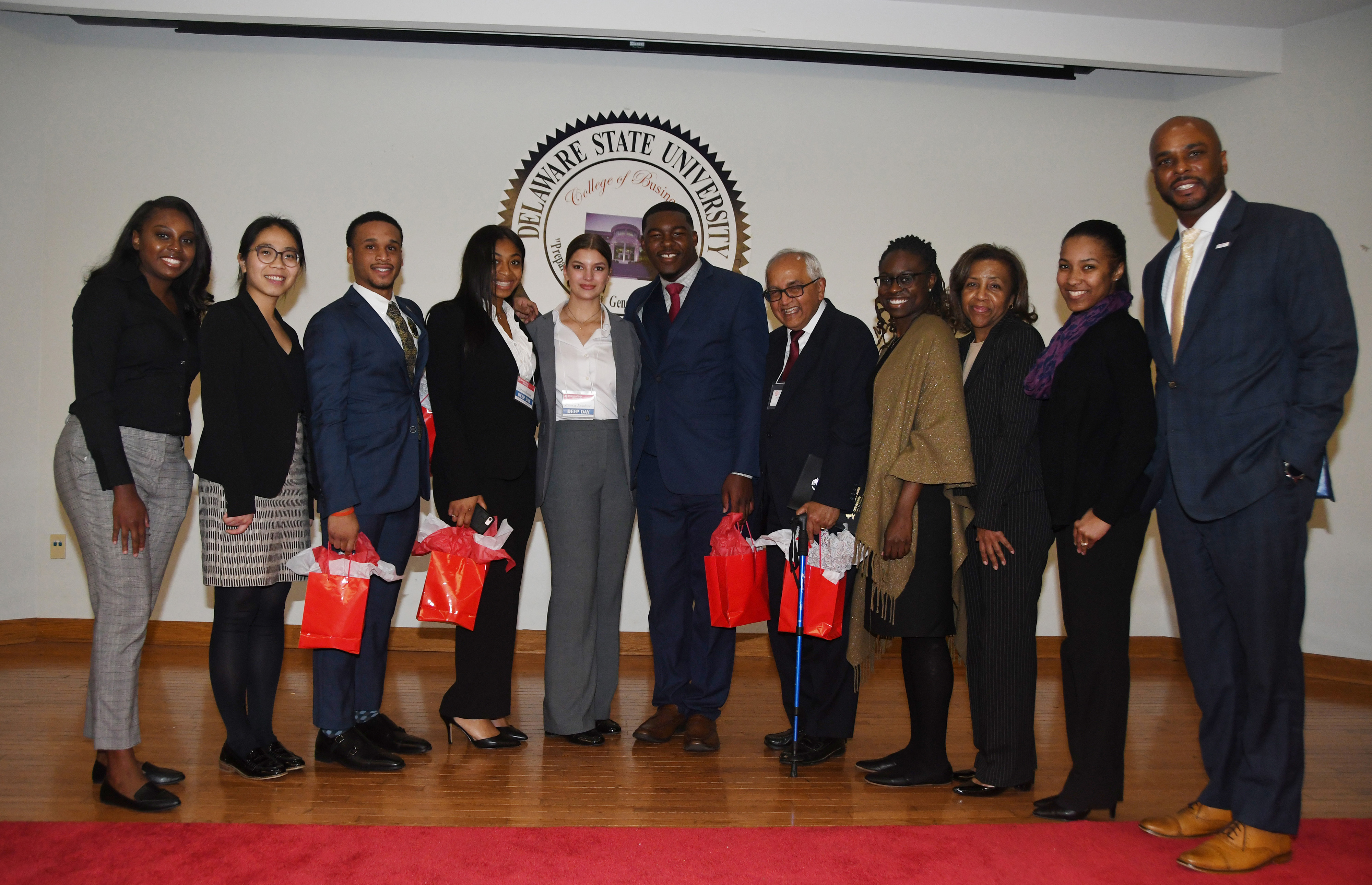 The Gates visitors pose with the Project LEAD Business Case Competition winners during the College of Business' Deep Day. (L-r) Gates team members, Lillian Williams and Julie Ngyuen; students Chris Whitney-Smith, Coreia Benson, Bianca Jacobson and Tysun Hicks, advisor Dr. Chandrakant P. Ganatra; and American Institute for Research members Deaweh Benson, Dr. Kathy Thompson and Dr. Montrisha Williams, along with Acting Dean Michael Casson Jr.