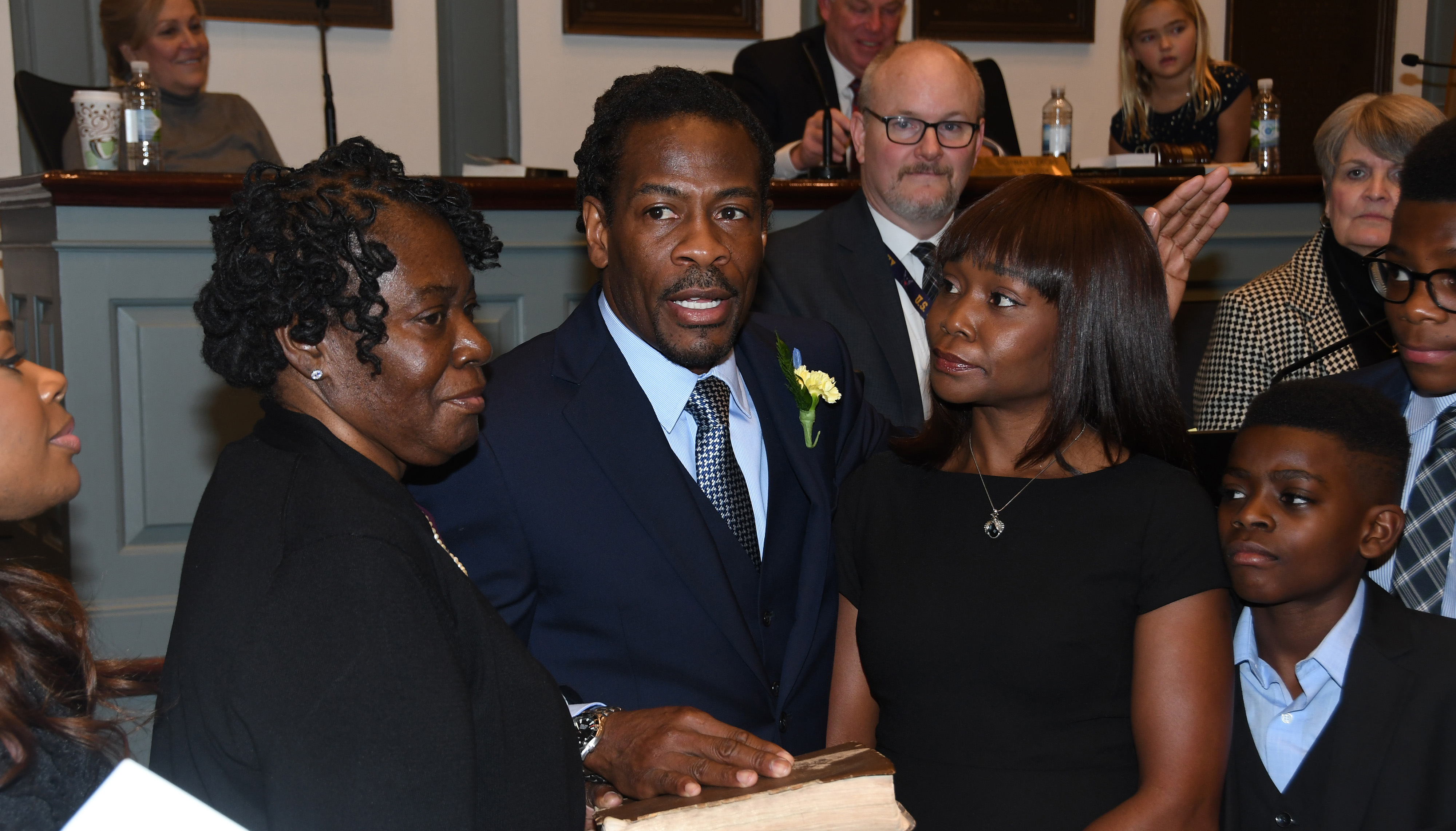 Newly elected Rep. Nnamdi Chukwuocha, surrounded by his family, is sworn in as a member of the Delaware House of Representatives by Delaware Supreme Court Justice James T. Vaughn, Jr. The new legislator's mother Mary Jones (l) holds the bible while his wife Chica stands to his right.