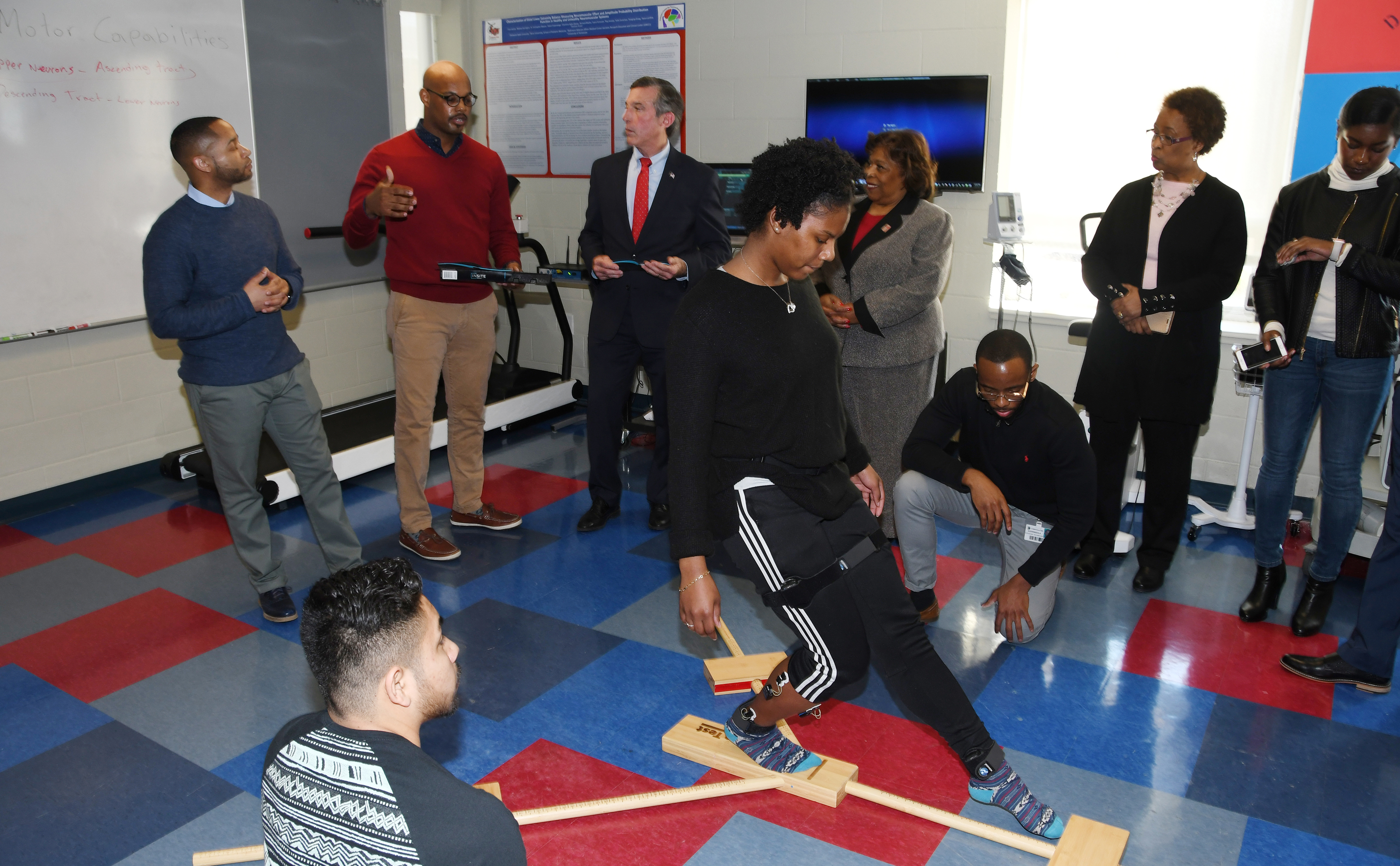 A kinesiology student does movements while electrodes measure electrical activity in her ankle muscles. This predictive injury analysis was part of a Feb. 5 demonstration presented (background l-r) by Dr. Chris Mason and Dr. Von Homer to Gov. John Carney, University President Wilma Mishoe and Dr. Marsha Horton, dean of the College of Health and Behavioral Sciences.