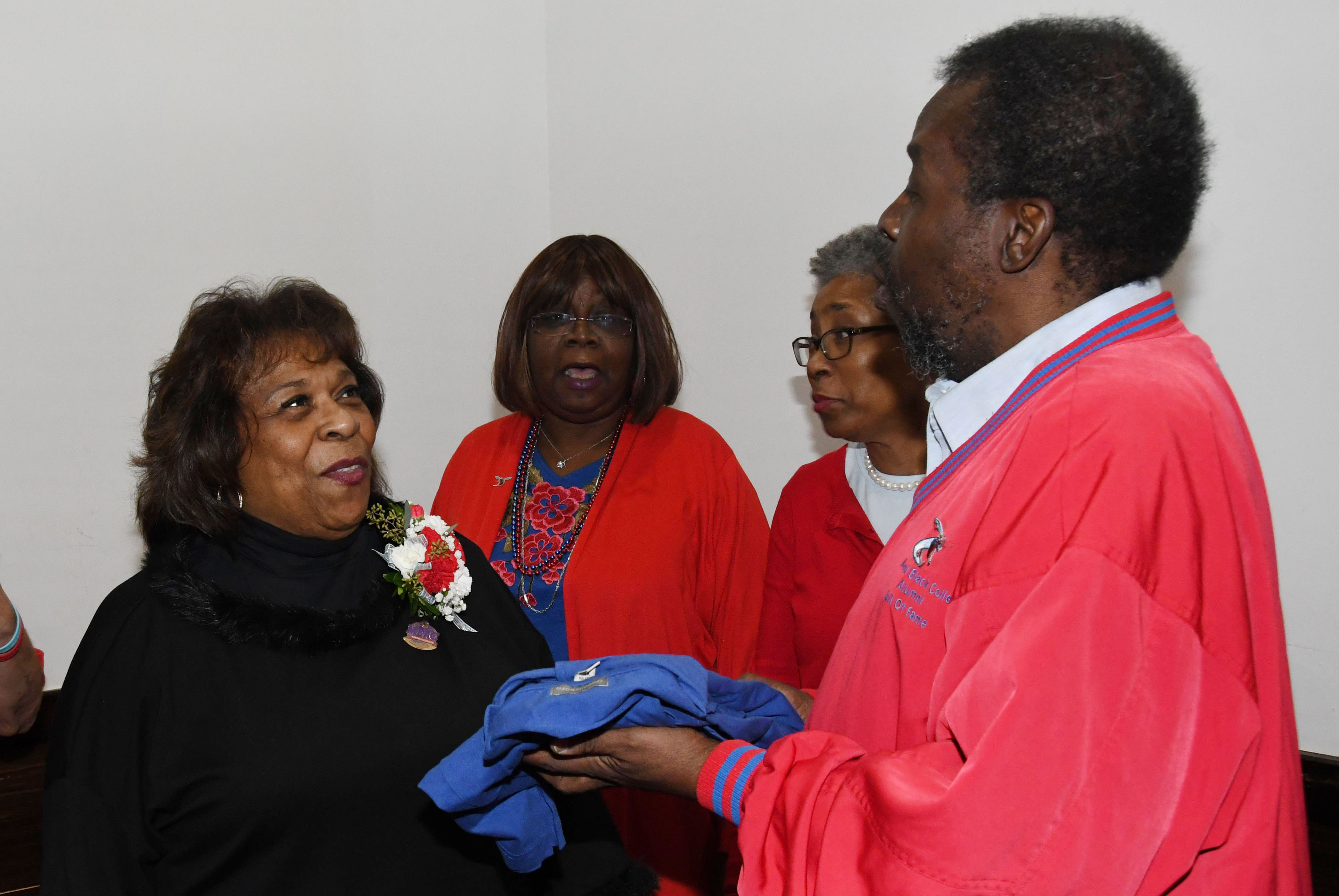 Alumnus Albert Weal (r) presents University President Wilma Mishoe with an alumni shirt during a dinner gathering during the MEAC Tourney.