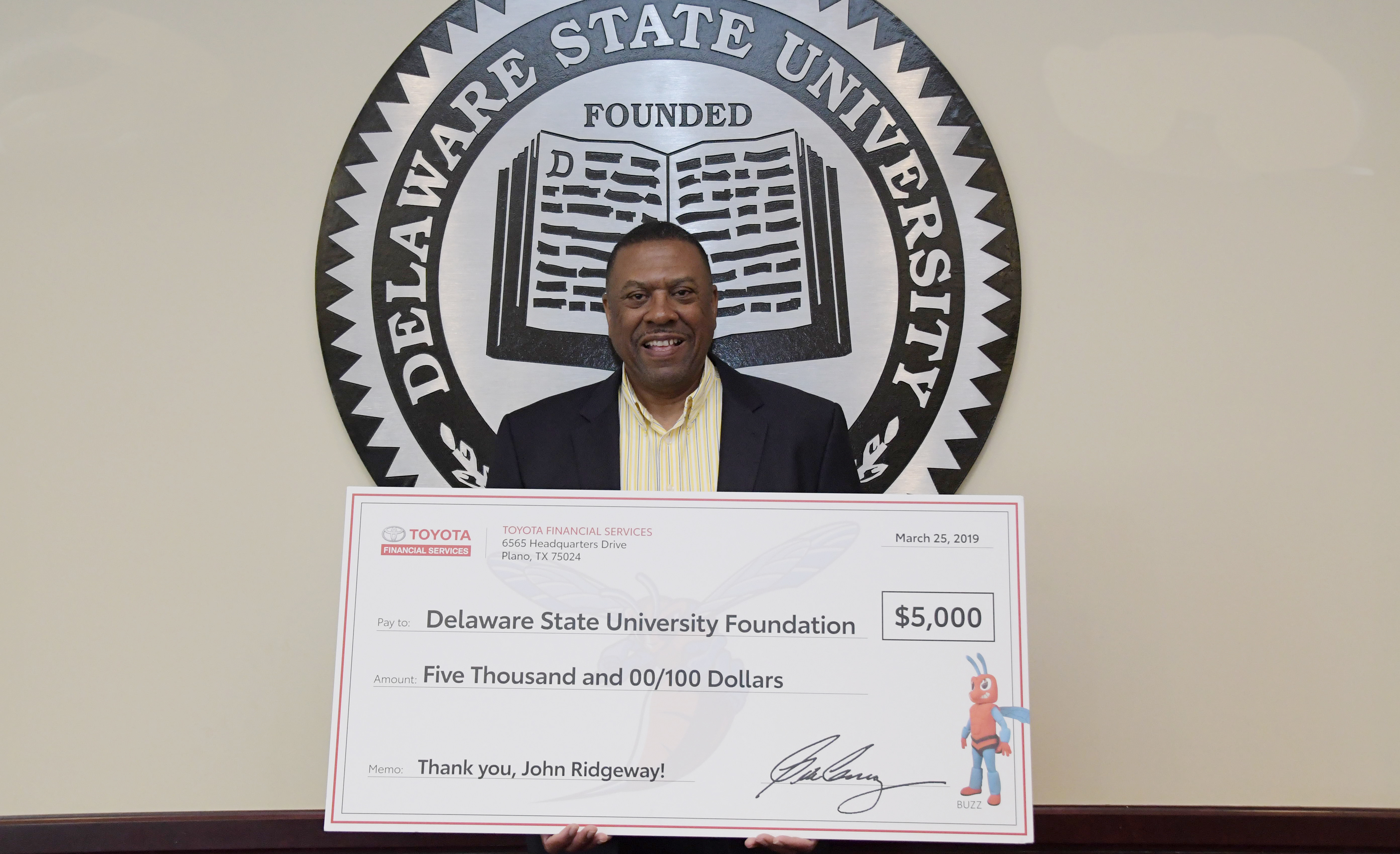 University Board of Trustees Vice Chair John Ridgeway shows a display check of a $5,000 gift presented as a donation by Toyota into an endowed scholarship he established with his wife Sherri. The donation was a retirement gift by Toyota; several other of his work colleague have also donated money into the endowment.