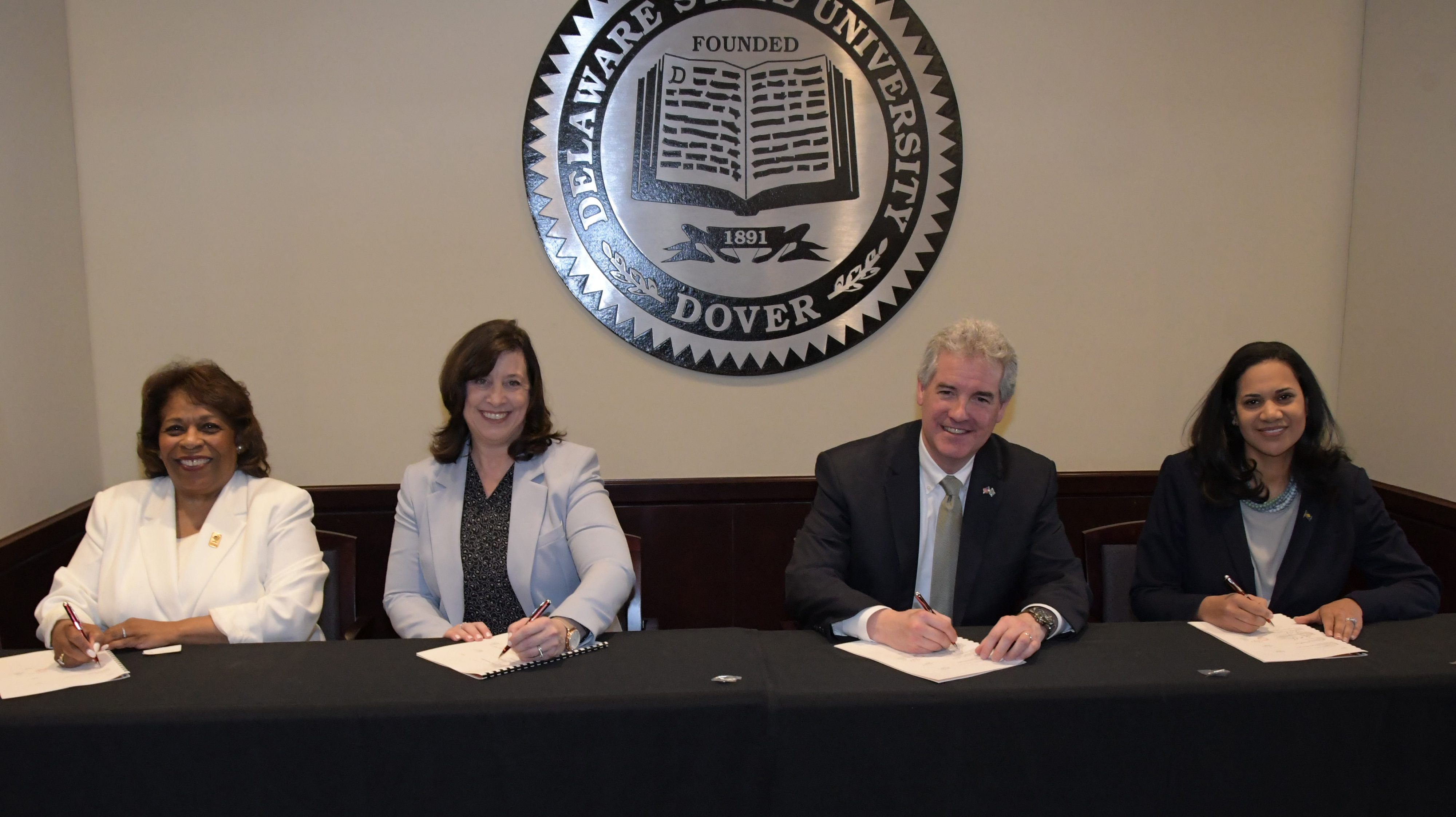 (L-r) University President Wilma Mishoe, EPA Deputy Director Cinday Caporale, DNREC Secretary Shawn M. Garvin and DHSS Secretary Kara Odom Walker sign a new agreement that will provide Delaware State University students internship and research opportunities as well as promote environmental stewardship at the institution.