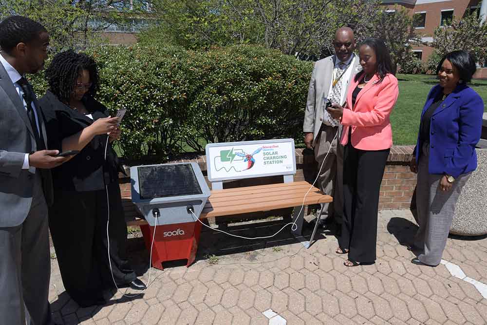 Some University employees try out one of the new solar benches installed outside of the William C. Jason Library and the Mishoe Science Center.