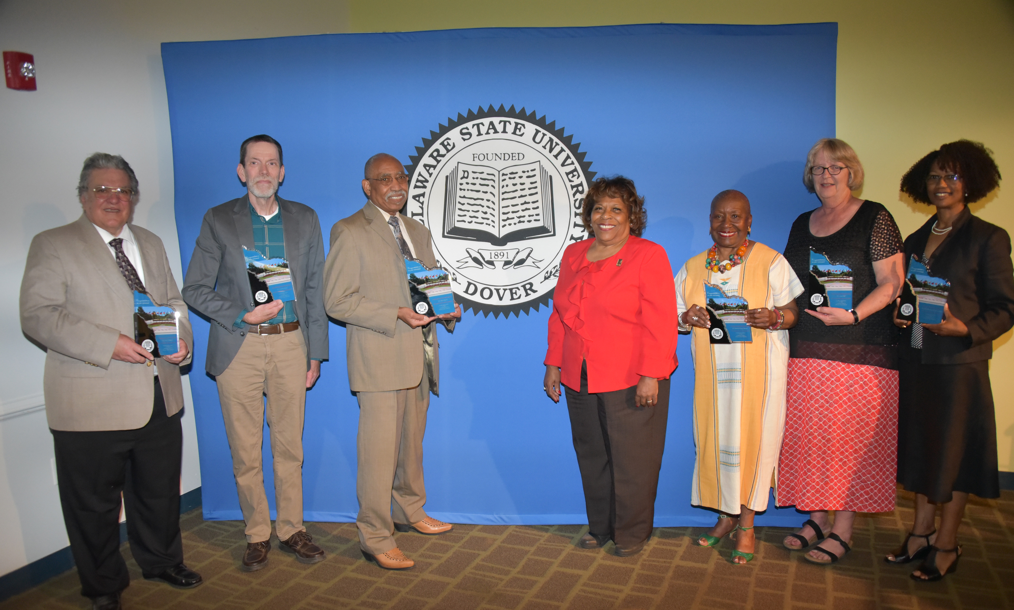 (L-r) 2018-2019 retirees Dr. Peter DiMaria, Dr. Andrew Lloyd, Dr. John Austin, University President Wilma Mishoe (who unretired herself to be the institution's CEO), Dr. Dolores Finger Wright, Dr. Janet Hill and Dr. Sheridan Quarless Kingsberry.