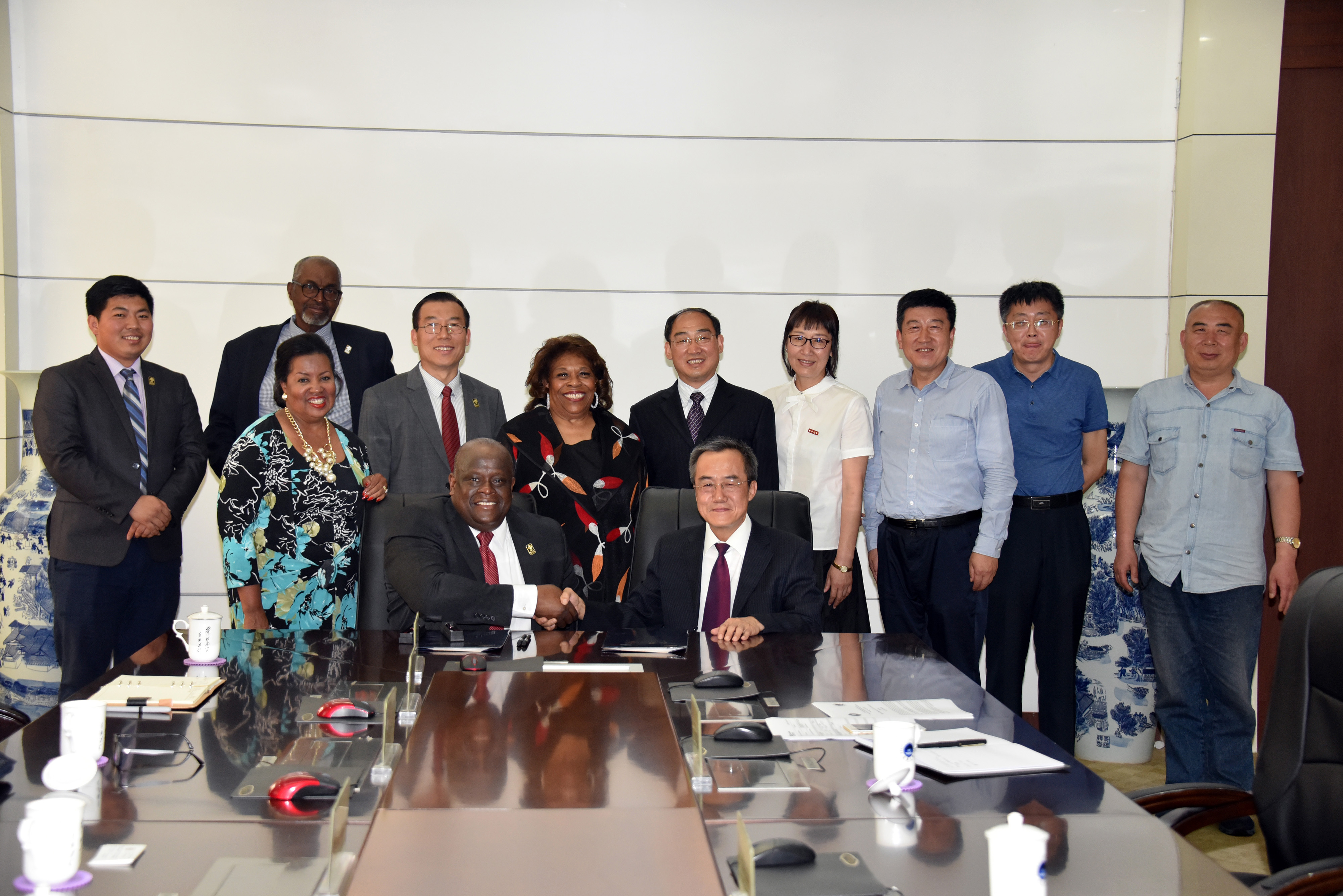 Tony Boyle, Vice President of Strategic Enrollment Management, and JiZong Qi, Vice President of Beihua University of China, shake hands after signing an agreement that establishes a joint English Language Institute in that Far East country.