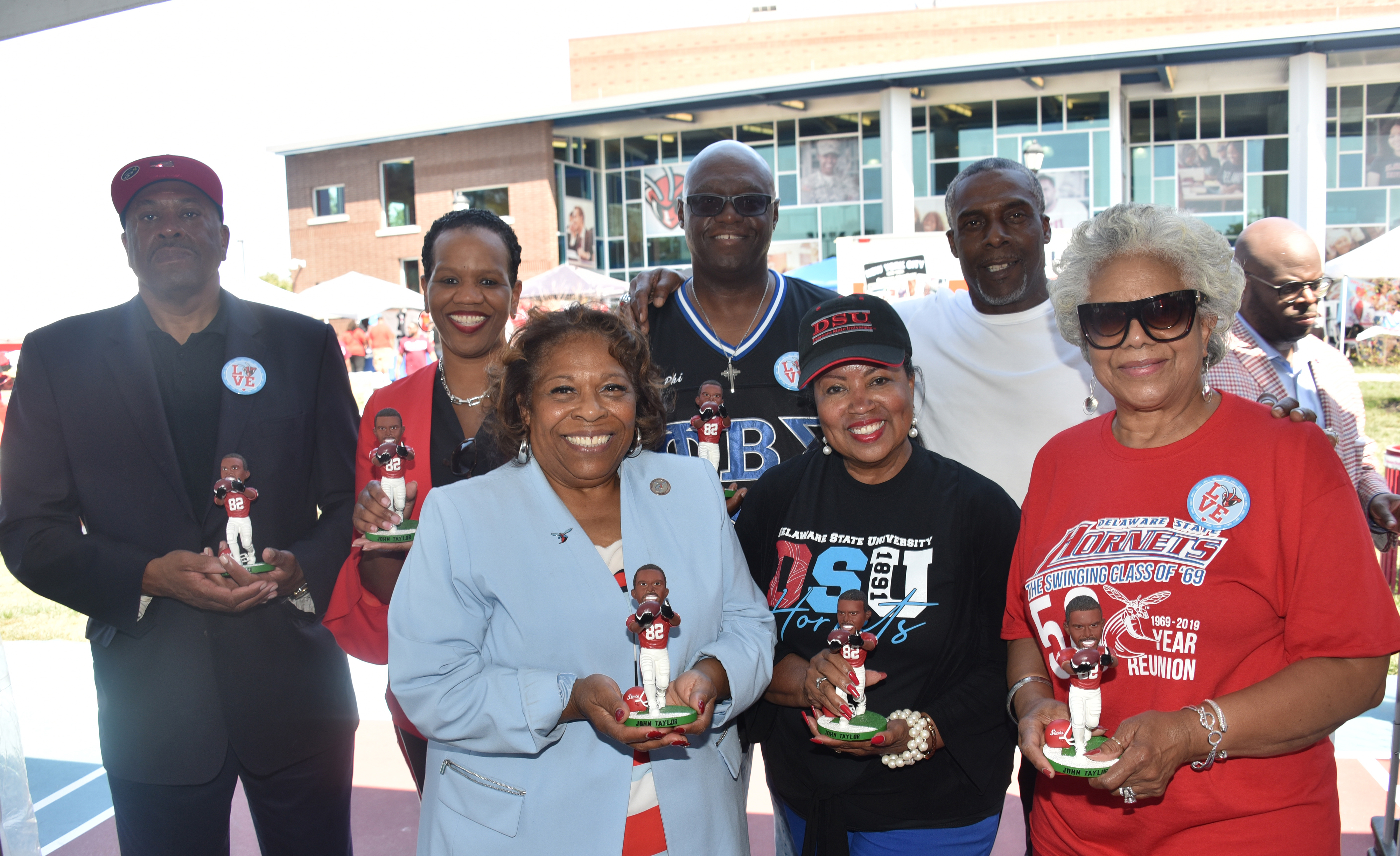 Hornet football alumnus and former NFL star John Taylor (2nd from the right) presents members of the University Board of Trustees and Dr. Wilma Mishoe with a signed bobble head likeness of himself.