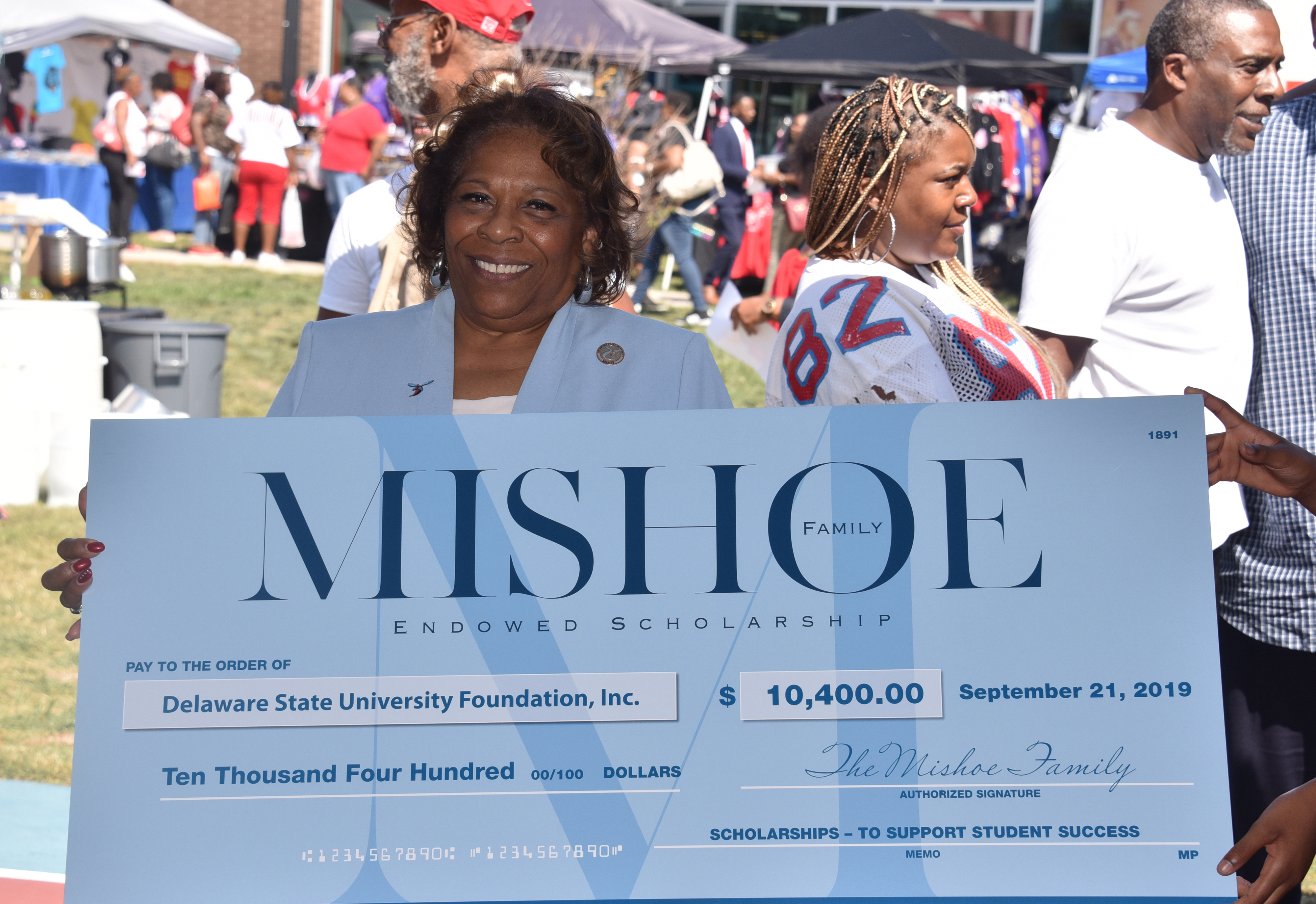 University President Wilma Mishoe holds a display check on behalf of her family that signals the establishment of the Mishoe Endowed Scholarship.