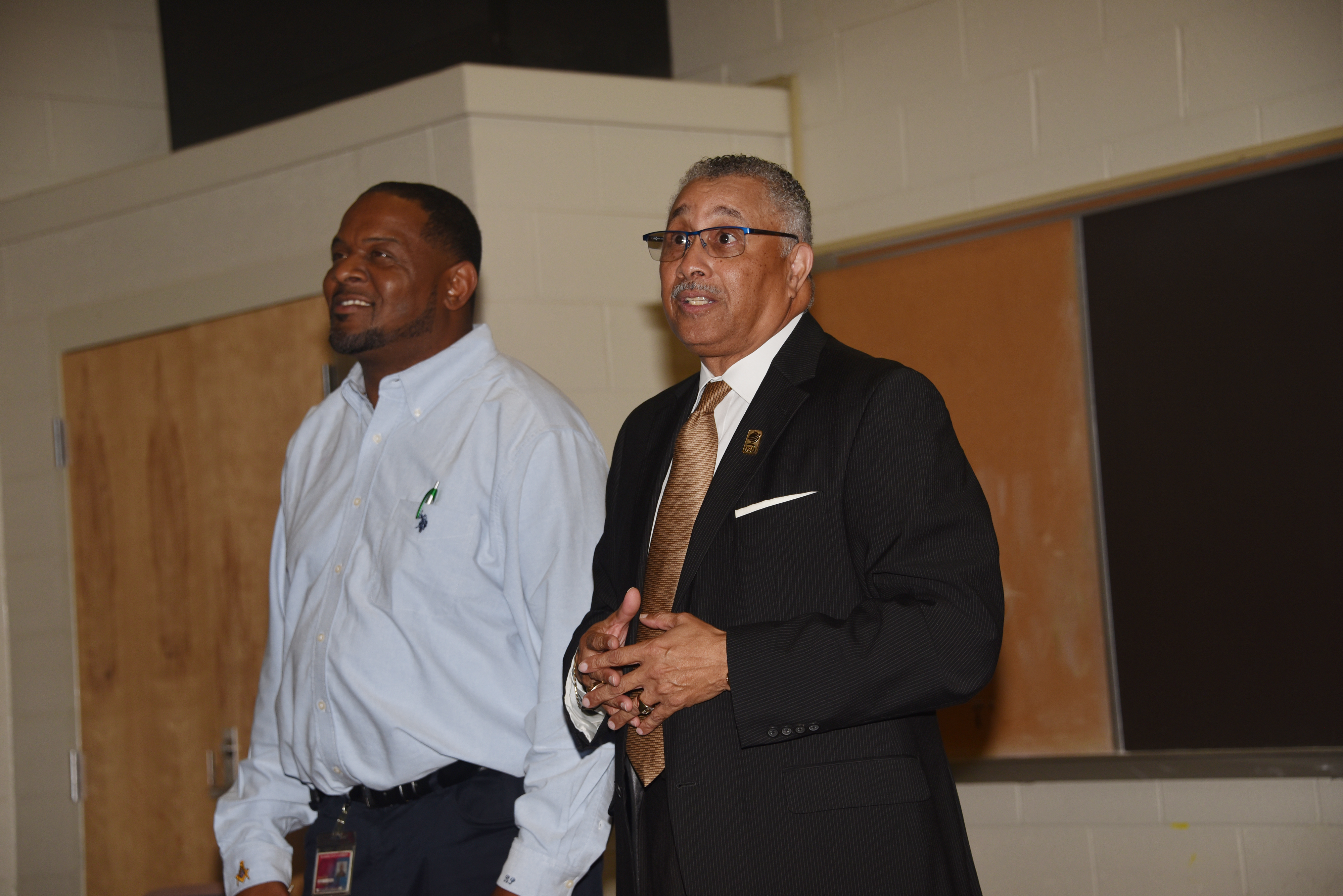 Herman Wood, the new Associate Vice President of Facilities Management, Planning and Construction, introduces himself to the custodial staff as Bernard Pratt, Senior Director of Plant Maintenance stands alongside.