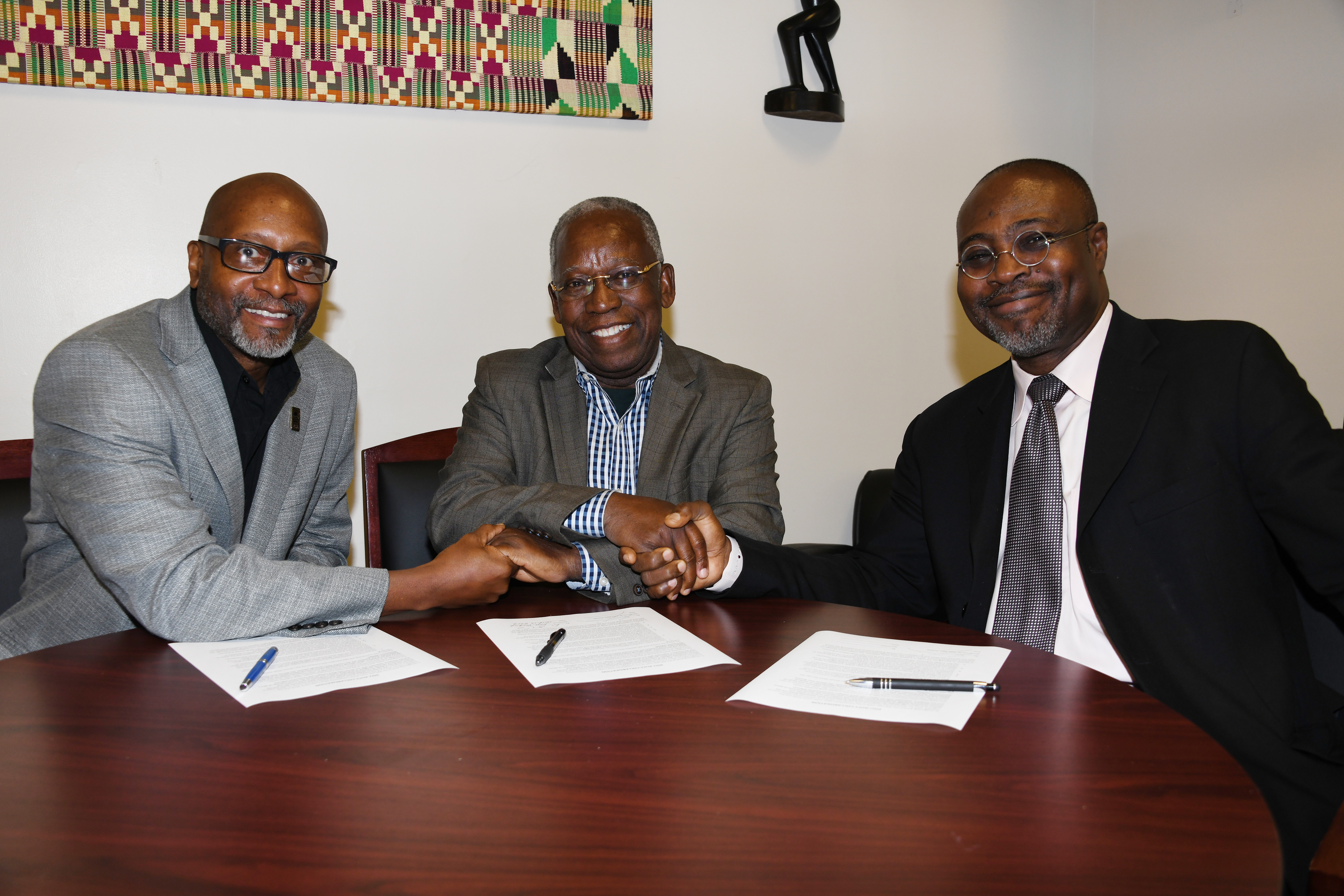 (L-r) Ezrah Aharone, director of the University's Center for Global Africa; Kojo Yankah, founder of the African University College of Communications in Ghana; and Dr. Akwasi Osei, associate dean of the College of Humanities, Education and Social Sciences, shake hands after signing a collaboration agreement between the two institutions.