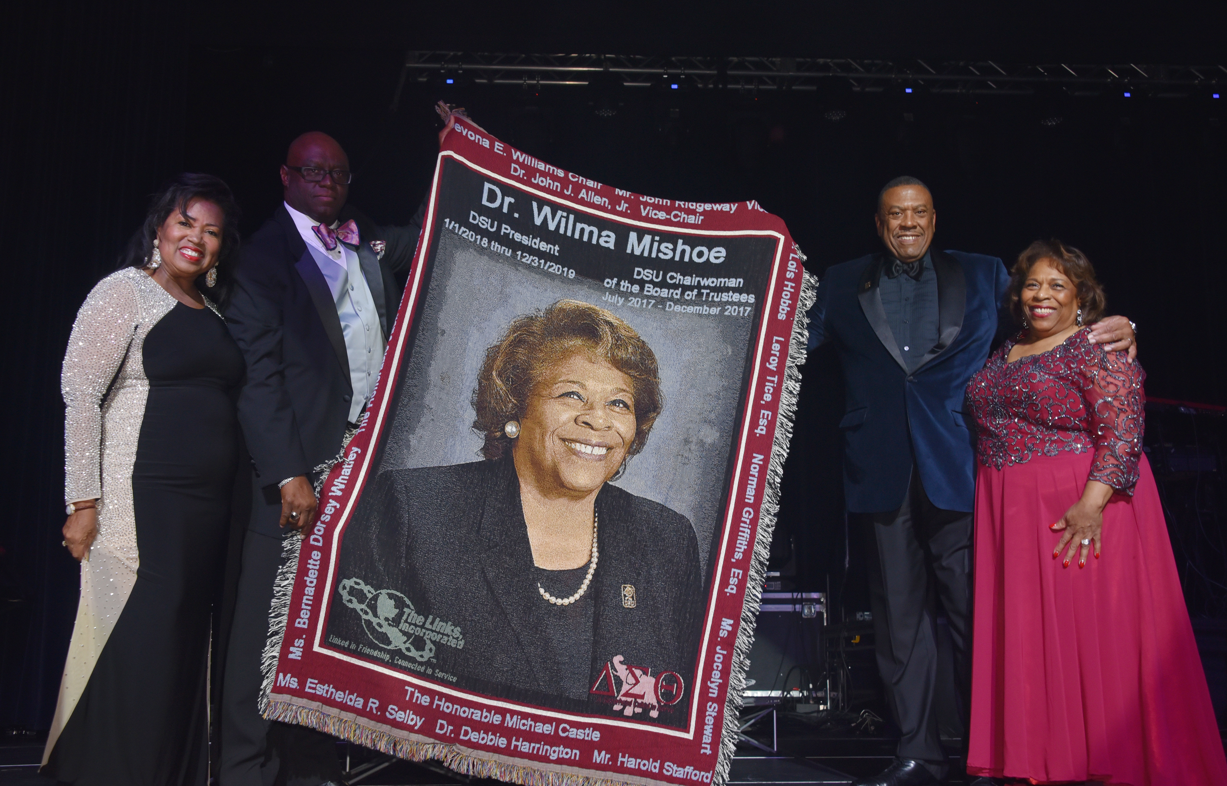 (L-r) Board of Trustees Chairperson Devona Williams, Trustee John Allen, and Vice Chairperson John Ridgeway presented outgoing University President Wilma Mishoe with an afghan bearing her portrait image in recognition of her presidential service to the institution.